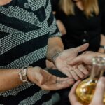 a man and a woman holding hands over a wine glass