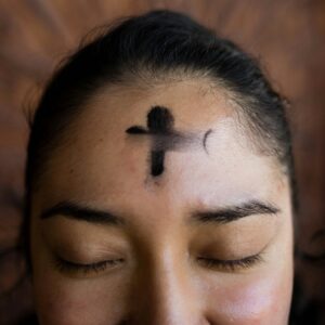 woman with black cross tattoo on her face